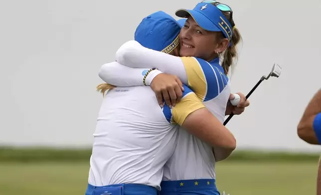 Europe's Emily Pedersen, right, hugs teammate Europe's Maja Stark after their victory on the 18th green during a Solheim Cup golf tournament foursomes match at Robert Trent Jones Golf Club, Friday, Sept. 13, 2024, in Gainesville, Va. (AP Photo/Matt York)