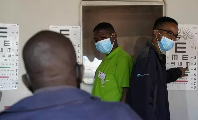 Optometry students carry out an eye test for a patient, outside the Phelophepa eye clinic carriage, in Tembisa, east of Johannesburg, South Africa, Thursday, Aug. 22, 2024. (AP Photo/Themba Hadebe)