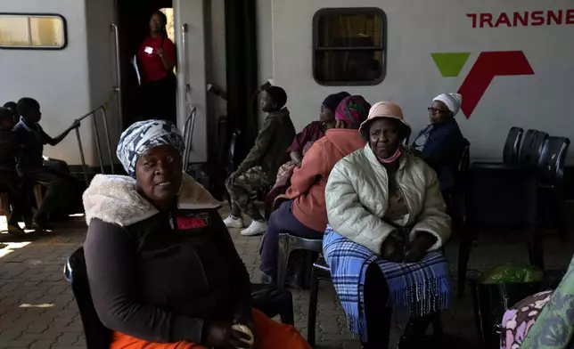 Patients queue for an eyes test, outside the Phelophepa eye clinic carriage, in Tembisa, east of Johannesburg, South Africa, Thursday, Aug. 22, 2024. (AP Photo/Themba Hadebe)