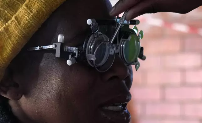 A patient eyes are tested for lenses to be made for a new pair of glasses outside the Phelophepa eye clinic carriage, in Tembisa east of Johannesburg, South Africa, Thursday, Aug. 22, 2024. (AP Photo/Themba Hadebe)