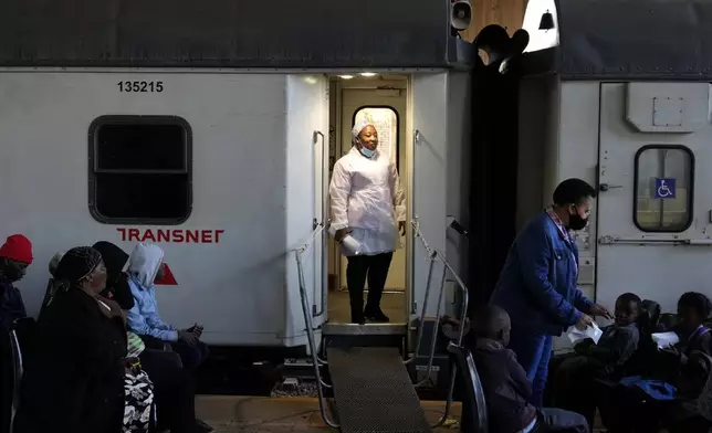 A healthcare worker stands at the door of the Phelophepa eye clinic carriage, in Tembisa, east of Johannesburg, South Africa, Thursday, Aug. 22, 2024. (AP Photo/Themba Hadebe)