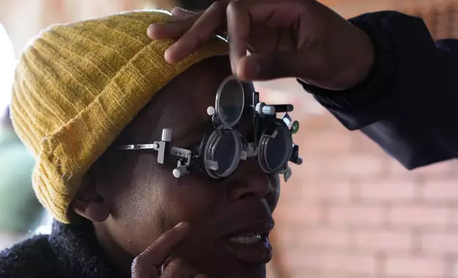 A patient eyes are tested for lenses to be made for a new pair of glasses outside the Phelophepa eye clinic carriage, in Tembisa, east of Johannesburg, South Africa, Thursday, Aug. 22, 2024. (AP Photo/Themba Hadebe)