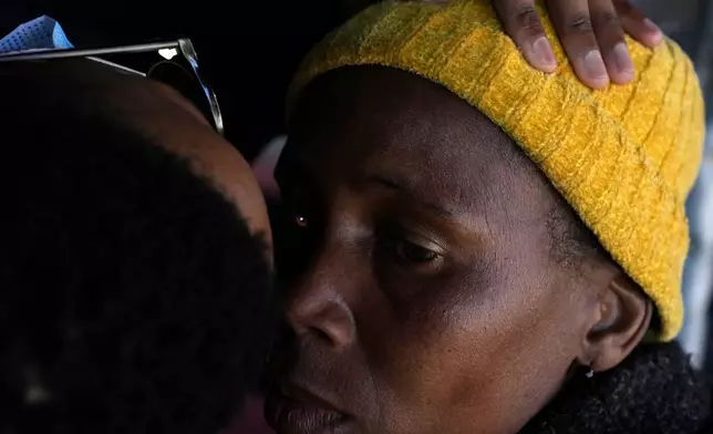 A patient has an eye examined by an optometry student, outside the Phelophepa eye clinic carriage, in Tembisa, east of Johannesburg, South Africa, Thursday, Aug. 22, 2024. (AP Photo/Themba Hadebe)