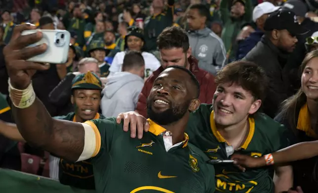 South Africa's captain Siya Kolisi takes a selfie with fans at the end of a rugby championship test match between South Africa and New Zealand at Ellis Park stadium in Johannesburg, South Africa, Saturday, Aug. 31, 2024. (AP Photo/Themba Hadebe)