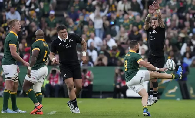 New Zealand's TJ Perenara, right, blocks a kick by South Africa's Cobus Reinach during a rugby championship test match between South Africa and New Zealand at Ellis Park stadium in Johannesburg, South Africa, Saturday, Aug. 31, 2024. (AP Photo/Themba Hadebe)