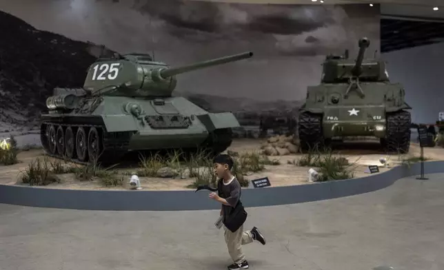 A boy runs across an exhibition hall displaying Sherman tanks, the main battle tanks used during the Korean War, at the War Memorial of Korea in Seoul, Wednesday, May 29, 2024. (AP Photo/Jae C. Hong)