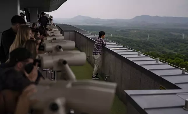 Tourists use binoculars to view North Korea from the Dora Observation Post in the Demilitarized Zone (DMZ) in Paju, South Korea, Saturday, May 25, 2024. (AP Photo/Jae C. Hong)