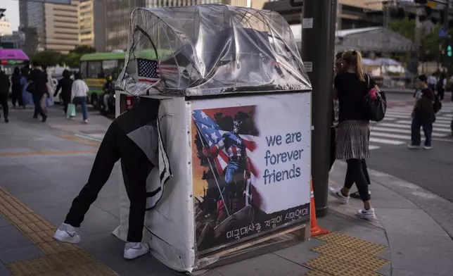 Jung Dong-won, a group member organized to show support for and protect the U.S. embassy, enters a small booth adorned with a Captain America image across the street from the embassy in Seoul on Thursday, May 23, 2024. (AP Photo/Jae C. Hong)