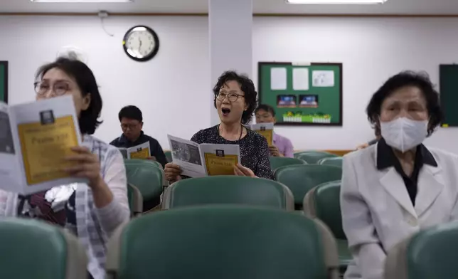 Choi Young-kyung, center, a retired piano tutor, sings in the choir practice room at Youngnak Presbyterian Church in Seoul, Sunday, May 26, 2024. "I don't think North Korea can easily start a war as long as the U.S. military is stationed in South Korea. They know that the U.S. will retaliate if they attack us," said Choi. (AP Photo/Jae C. Hong)