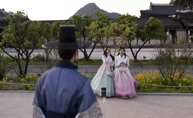 Two women dressed in traditional hanbok laugh as they pose for photos at Gyeongbok Palace, the main royal palace during the Joseon Dynasty, in Seoul, Thursday, May 23, 2024. (AP Photo/Jae C. Hong)d