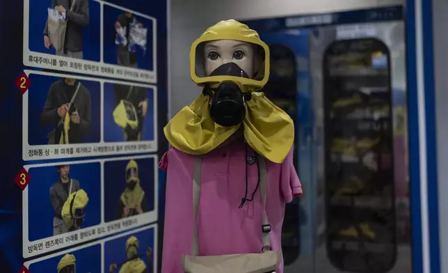 A mannequin wearing a gas mask stands next to a board explaining how to put it on at the War Memorial of Korea in Seoul, Wednesday, May 29, 2024. (AP Photo/Jae C. Hong)