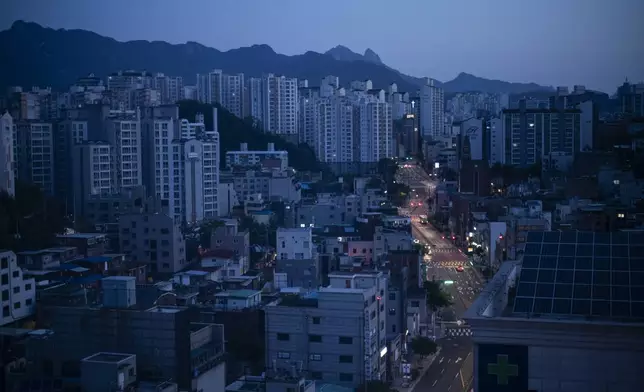 Cars drive along quiet roads at dawn in Seoul with Bukhan Mountain in the distance, Friday, May 17, 2024. (AP Photo/Jae C. Hong)