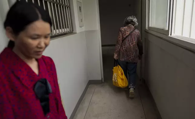 Yooree Kim, left, who was 11 when she was adopted from South Korea to a couple in France, stands by her apartment door after seeing off her biological mother, who had visited her in Seoul, South Korea, Friday, May 24, 2024. Their relationship is strained, with years of separation and unresolved emotions lingering between them. (AP Photo/Jae C. Hong)