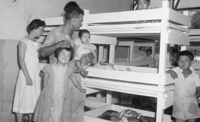 Oregon farmer Harry Holt stands with a group of South Korean orphans who were scheduled to depart for the United States as part of Holt's adoption program, in Seoul, South Korea, July 21, 1958. (AP Photo/Kim Chon-kil, File)