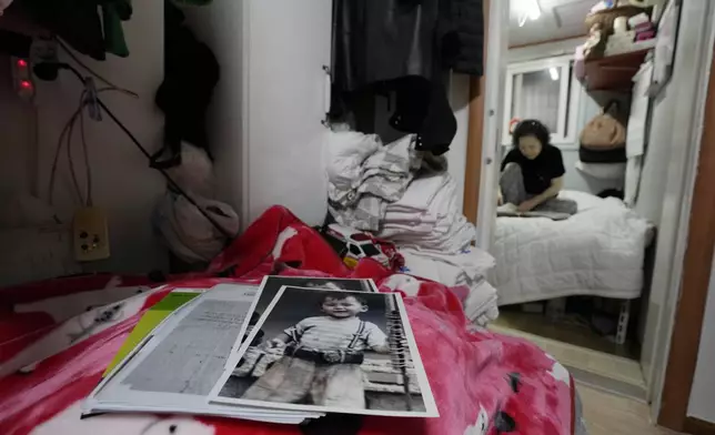 Photos of Choi Young-ja's son, Paik Sang-yeol, who went missing in 1975, sit on a bed in her motel room in Seoul, South Korea, Tuesday, March 5, 2024. (AP Photo/Ahn Young-joon)