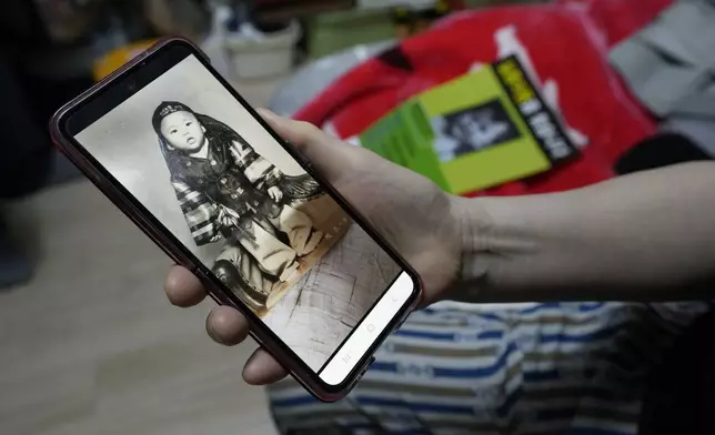 Choi Young-ja holds a smartphone displaying a photo of her son, who went missing in 1975, as she sits in her motel room in Seoul, South Korea, Tuesday, March 5, 2024. (AP Photo/Ahn Young-joon)