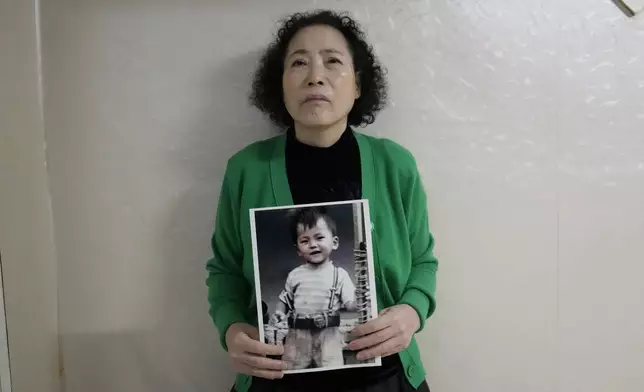 Choi Young-ja holds a photo of her son, who went missing in 1975, in her motel room in Seoul, South Korea, Tuesday, March 5, 2024. (AP Photo/Ahn Young-joon)