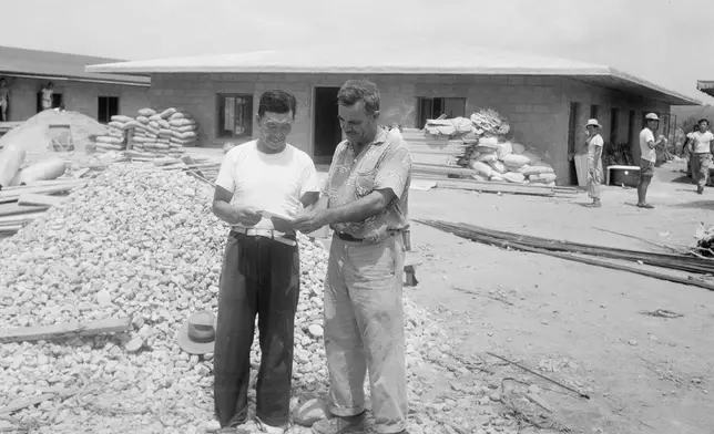 Oregon farmer Harry Holt, right, stands in front of a new orphanage he is building in Seoul, South Korea, July 21, 1958. It served as a temporary home for orphans awaiting homes abroad as part of Holt's adoption program. (AP Photo/Kim Chon-kil, File)