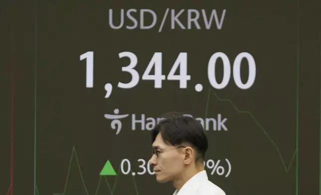 A currency trader walks by the screens showing the foreign exchange rate between U.S. dollar and South Korean won at a foreign exchange dealing room in Seoul, South Korea, Wednesday, Sept. 11, 2024. (AP Photo/Lee Jin-man)