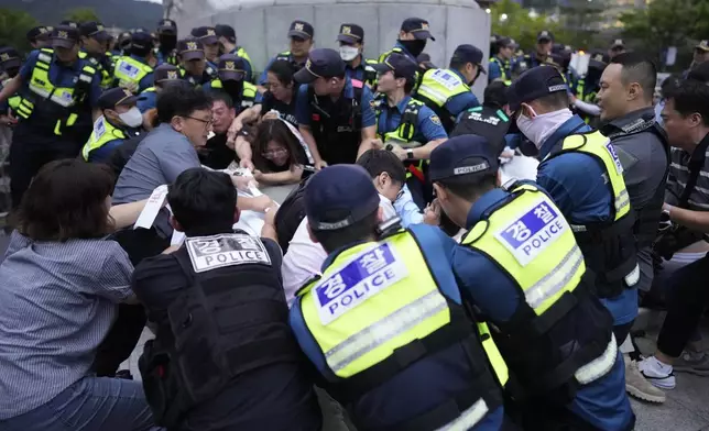 South Korean police officers try to remove a huge banner from protesters during a rally opposing the meeting between South Korean President Yoon Suk Yeol and Japanese Prime Minister Fumio Kishida in Seoul, South Korea, Friday, Sept. 6, 2024. (AP Photo/Lee Jin-man)