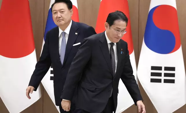 South Korean President Yoon Suk Yeol, left, and Japanese Prime Minister Fumio Kishida, right, walk to their chairs during a meeting at the Presidential Office in Seoul, South Korea, Friday, Sept. 6, 2024. (AP Photo/Lee Jin-man, Pool)