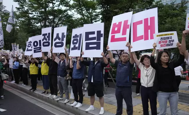 Protesters hold signs reading "Oppose the meeting between South Korea and Japan," during a rally opposing the meeting between South Korean President Yoon Suk Yeol and Japanese Prime Minister Fumio Kishida in Seoul, South Korea, Friday, Sept. 6, 2024. (AP Photo/Lee Jin-man)