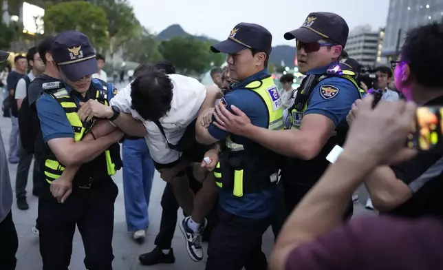 A protester is detained by police officers as he stages a rally opposing the meeting between South Korean President Yoon Suk Yeol and Japanese Prime Minister Fumio Kishida in Seoul, South Korea, Friday, Sept. 6, 2024. (AP Photo/Lee Jin-man)