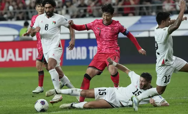 South Korea's Son Heung-min, center, is tackled by Palestine's Michael Termanini during the Asian qualifier group B match for 2026 World Cup between South Korea and Palestine at Seoul World Cup Stadium in Seoul, South Korea, Thursday, Sept. 5, 2024. (AP Photo/Ahn Young-joon)