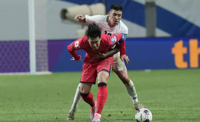 South Korea's Son Heung-min, bottom, fights for the ball with Jonathan Zorrilla during the Asian qualifier group B match for 2026 World Cup between South Korea and Palestine at the World Cup Stadium in Seoul, South Korea, Thursday, Sept. 5, 2024. (AP Photo/Ahn Young-joon)