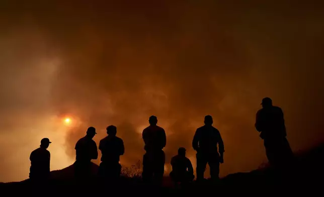 Firefighters monitor the advancing Line Fire in Angelus Oaks, Calif., Monday, Sept. 9, 2024. (AP Photo/Eric Thayer)