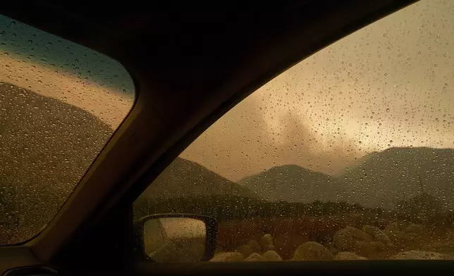 Smoke is seen from the advancing Line Fire through a car window in Mentone, Calif., Sunday, Sept. 8, 2024. (AP Photo/Eric Thayer)