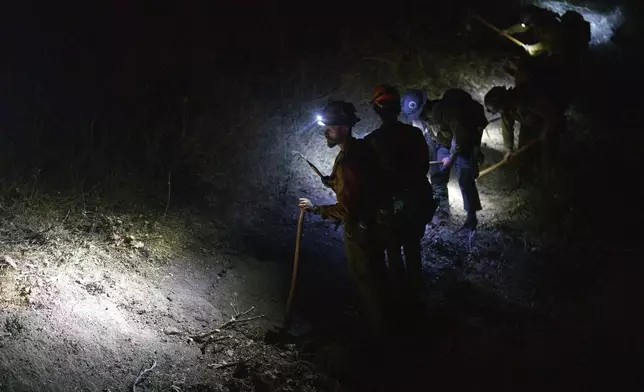 Firefighting hand crews cut lines against the advancing Line Fire in Running Springs, Calif., Monday, Sept. 9, 2024. (AP Photo/Eric Thayer)