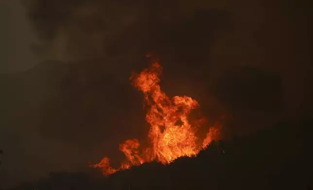 Flames from the Line Fire rise over a hilltop Saturday, Sept. 7, 2024, near Running Springs, Calif. (AP Photo/Eric Thayer)