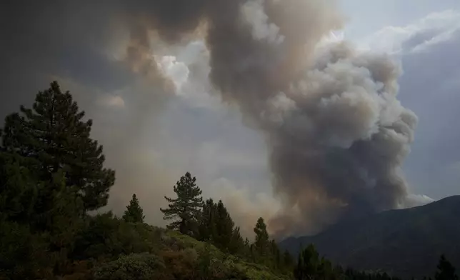 A cloud of smoke from the Line Fire rises over the mountains Saturday, Sept. 7, 2024, in Running Springs, Calif. (AP Photo/Eric Thayer)