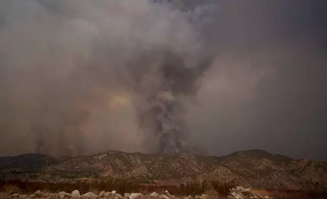 Smoke from the advancing Line Fire rises above a ridge in Mentone in San Bernardino County, Calif., Sunday, Sept. 8, 2024. (AP Photo/Eric Thayer)