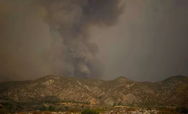 Smoke from the advancing Line Fire rises above a ridge in Mentone in San Bernardino County, Calif., Sunday, Sept. 8, 2024. (AP Photo/Eric Thayer)