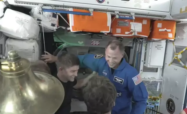 NASA’s Nick Hague in blue enters the International Space Station from the SpaceX capsule Dragon, Sunday, Sept. 29, 2024. (NASA via AP)