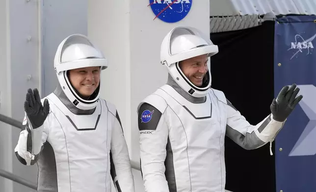 Roscosmos cosmonaut Aleksandr Gorbunov, left, and NASA astronaut Nick Hague wave as they leave the Operations and Checkout Building on their way to Launch Complex 40 for a mission to the International Space Station Saturday, Sept. 28, 2024 at Cape Canaveral, Fla., (AP Photo/John Raoux)