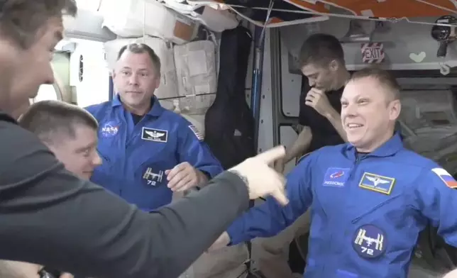 In blue suits, NASA’s Nick Hague, left, and the Russian Space Agency’s Alexander Gorbunov enter the International Space Station from the SpaceX capsule Dragon, Sunday, Sept. 29, 2024. (NASA via AP)