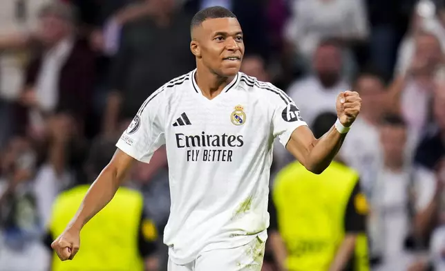 Real Madrid's Kylian Mbappe celebrates after scoring the opening goal during the Champions League opening phase soccer match between Real Madrid and VfB Stuttgart at the Santiago Bernabeu stadium, in Madrid, Tuesday, Sept. 17, 2024. (AP Photo/Manu Fernandez)