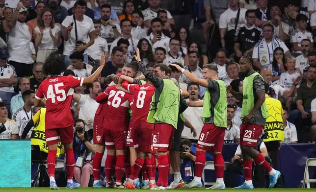 Stuttgart players celebrate their side's first goal during the Champions League opening phase soccer match between Real Madrid and VfB Stuttgart at the Santiago Bernabeu stadium, in Madrid, Tuesday, Sept. 17, 2024. (AP Photo/Manu Fernandez)