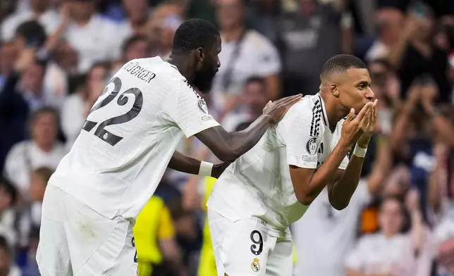 Real Madrid's Kylian Mbappe, right, celebrates with teammate Antonio Rudiger after scoring the opening goal during the Champions League opening phase soccer match between Real Madrid and VfB Stuttgart at the Santiago Bernabeu stadium, in Madrid, Tuesday, Sept. 17, 2024. (AP Photo/Manu Fernandez)