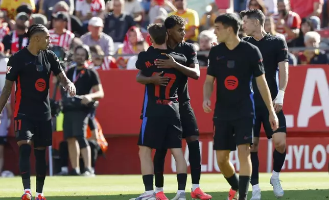 Barcelona's Lamine Yamal, centre, celebrates with his teammates after scoring his side's opening goal during the Spanish La Liga soccer match between Girona and Barcelona at the Montilivi stadium in Girona, Spain, Sunday, Sept. 15, 2024. (AP Photo/Joan Monfort)