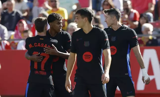 Barcelona's Lamine Yamal, second left, celebrates with his teammates after scoring his side's opening goal during the Spanish La Liga soccer match between Girona and Barcelona at the Montilivi stadium in Girona, Spain, Sunday, Sept. 15, 2024. (AP Photo/Joan Monfort)