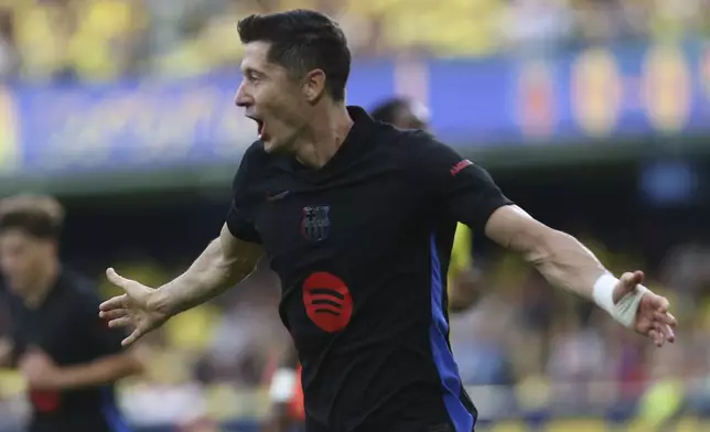 Barcelona's Robert Lewandowski celebrates after scoring the opening goal against Villarreal during a Spanish La Liga soccer match at the La Cerámica stadium in Villarreal, Spain, Sunday, Sept. 22, 2024. (AP Photo/Alberto Saiz)