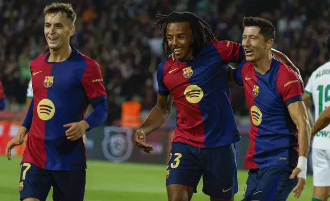 Barcelona's Robert Lewandowski, right, celebrates with teammates after scoring the opening goal during a Spanish La Liga soccer match between Barcelona and Getafe at the Olympic stadium in Barcelona, Spain, Wednesday, Sept. 25, 2024. (AP Photo/Joan Monfort)