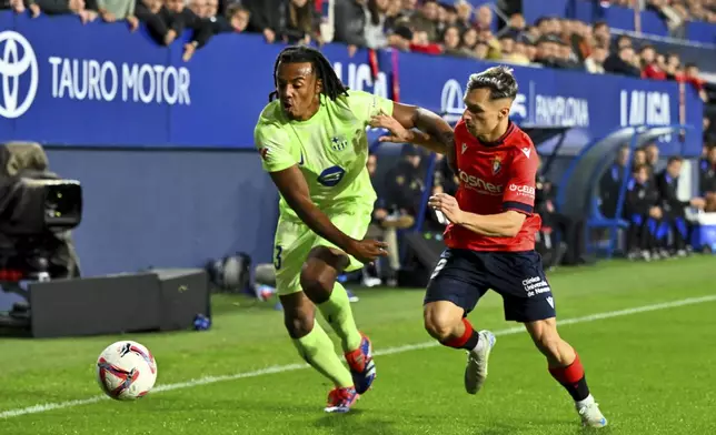 Osasuna's Bryan Zaragoza fights for the ball against Barcelona's Jules Kounde during a Spanish La Liga soccer match between Osasuna and Barcelona at El Sadar stadium in Pamplona, Spain, Saturday, Sept. 28, 2024. (AP Photo/Miguel Oses)