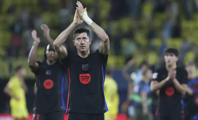 Barcelona's Robert Lewandowski, front, celebrates at the end of a Spanish La Liga soccer match against Villarreal at the La Cerámica stadium in Villarreal, Spain, Sunday, Sept. 22, 2024. Barcelona won the game 5-1.(AP Photo/Alberto Saiz)