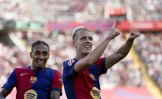 Barcelona's Dani Olmo, right, celebrates scoring his side's 6th goal during the Spanish La Liga soccer match between FC Barcelona and Valladolid at the Olympic stadium in Barcelona, Spain, Saturday, Aug. 31, 2024. (AP Photo/Joan Monfort)