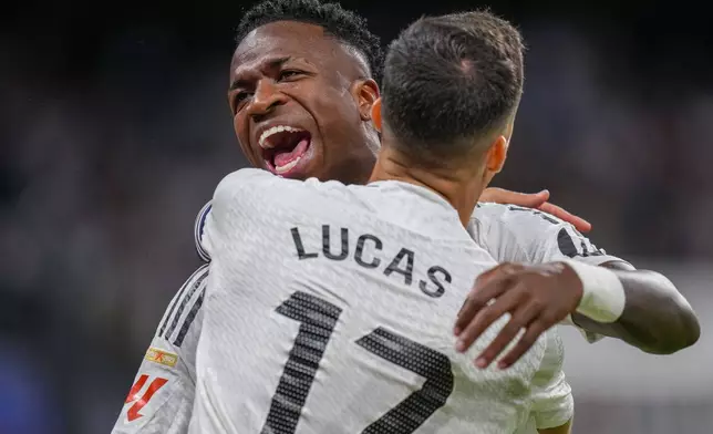 Real Madrid's Lucas Vazquez, front, celebrates with Real Madrid's Vinicius Junior after scoring the opening goal during a Spanish La Liga soccer match between Real Madrid and Alaves at Santiago Bernabeu stadium in Madrid, Spain, Tuesday, Sept. 24, 2024. (AP Photo/Manu Fernandez)